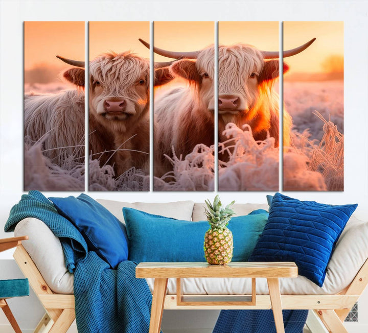 The "Highland Cows at Sunrise Wall Art Canvas Set" beautifully captures a serene and rustic farmhouse aesthetic, portraying two Highland cows in a frosty landscape at sunrise.