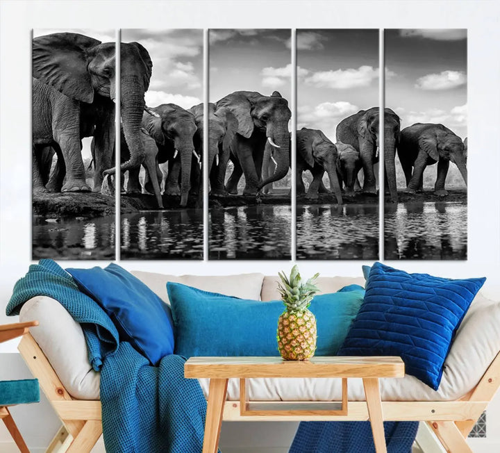 A stunning "Wall Art Animal Canvas Print" featuring a black and white photo of a herd of elephants drinking water is elegantly displayed, gallery wrapped on museum-quality canvas.