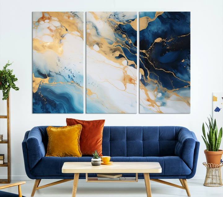 A modern living room featuring museum-quality Blue Gold Abstract Wall Art Print Contemporary art in a triptych arrangement.