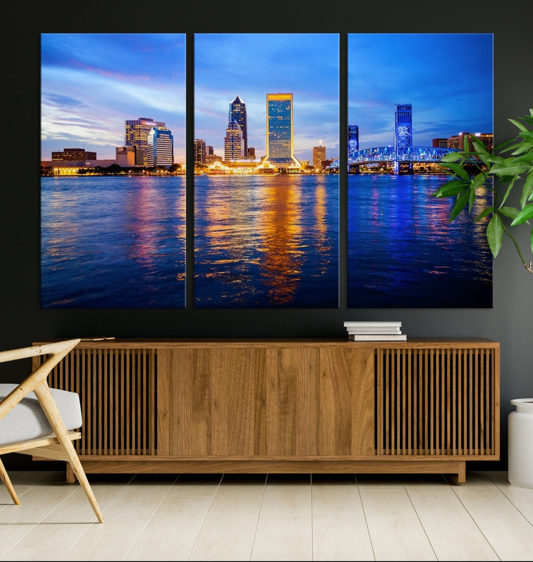 A cozy living room features the Jacksonville Wall Art Canvas Print, a large triptych crafted on museum-quality canvas that beautifully depicts the Jacksonville city skyline at sunset.