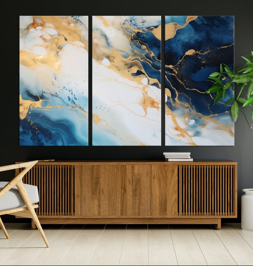 A modern living room featuring museum-quality Blue Gold Abstract Wall Art Print Contemporary art in a triptych arrangement.