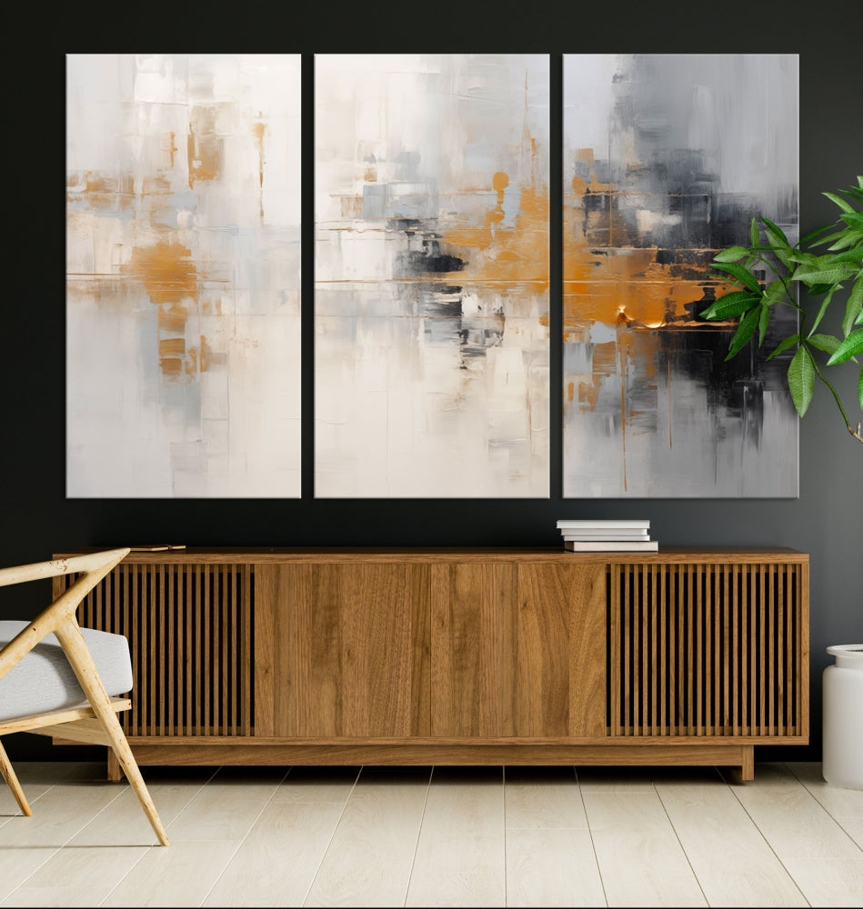 The Orange Pastel Abstract Wall Art Canvas Print, featuring a triptych of orange, white, and black hues, is elegantly displayed on museum-quality canvas.