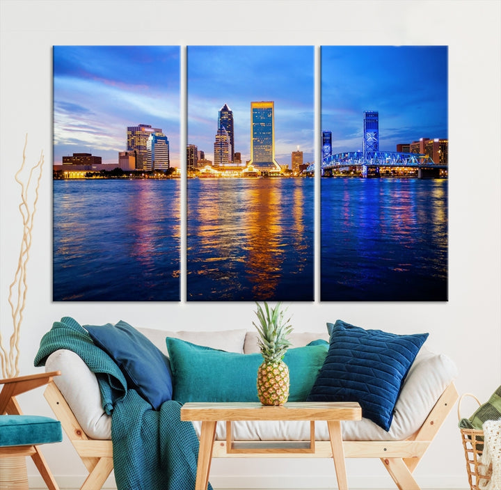 A cozy living room features the Jacksonville Wall Art Canvas Print, a large triptych crafted on museum-quality canvas that beautifully depicts the Jacksonville city skyline at sunset.