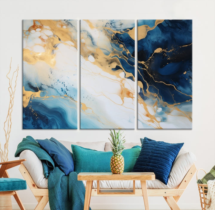 A modern living room featuring museum-quality Blue Gold Abstract Wall Art Print Contemporary art in a triptych arrangement.