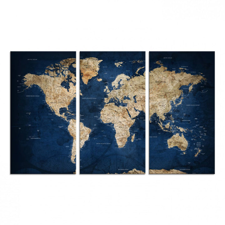 A large framed world map canvas print features beige landmasses set against a grunge-stained deep blue ocean background, creating an intriguing piece of wall art.