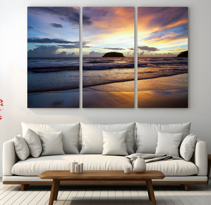 A tropical beach at sunset with waves gently washing ashore, reflecting golden and purple hues in the sky, creating a tranquil coastal scene.