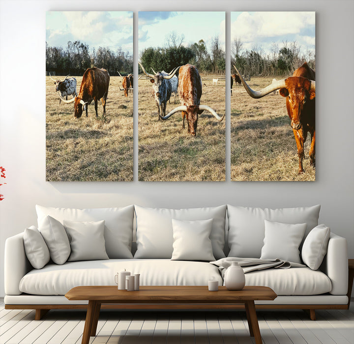 A herd of Texas Longhorn cattle grazing in an open field under a partly cloudy sky, capturing a rustic and Western ranch aesthetic.