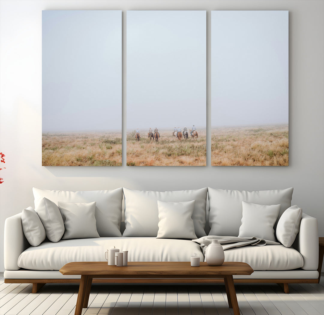 A group of horseback riders moving through a fog-shrouded field, evoking a calm Western scene with golden grasses and soft horizons.