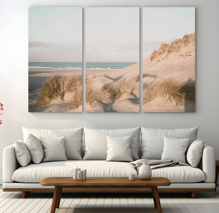 Soft pastel-toned beach scene with sand dunes, windswept grasses, and a calm ocean horizon, creating a serene coastal atmosphere.