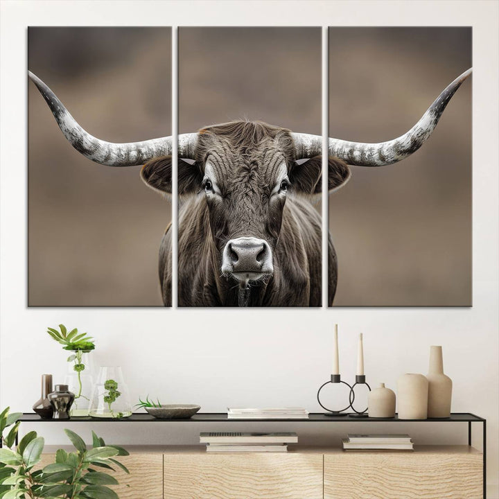 A close-up of a longhorn bull facing forward is featured in the Framed Texas Test-1, set against a blurred brown background.