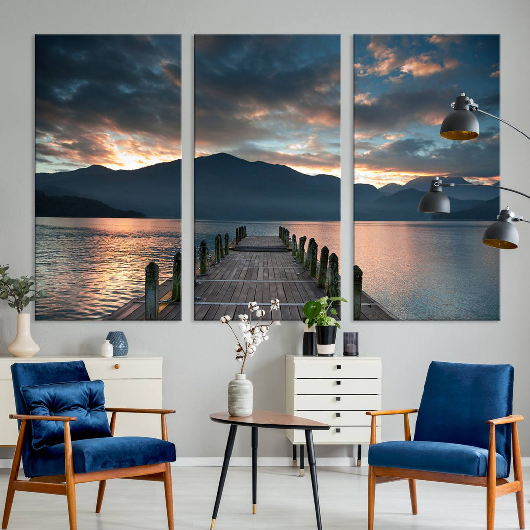 The Mountain Lake Wood Pier Canvas Wall Art depicts a serene lake and mountains, enhancing the beauty of any space.