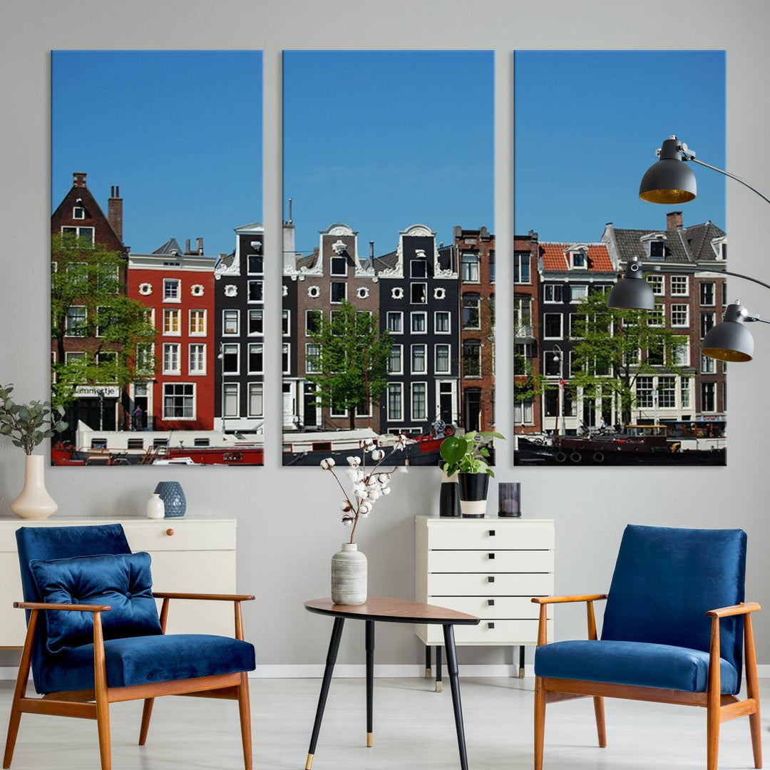 The Amsterdam City Wall Art Canvas Print showcases colorful traditional canal houses and boats set against a clear blue sky.