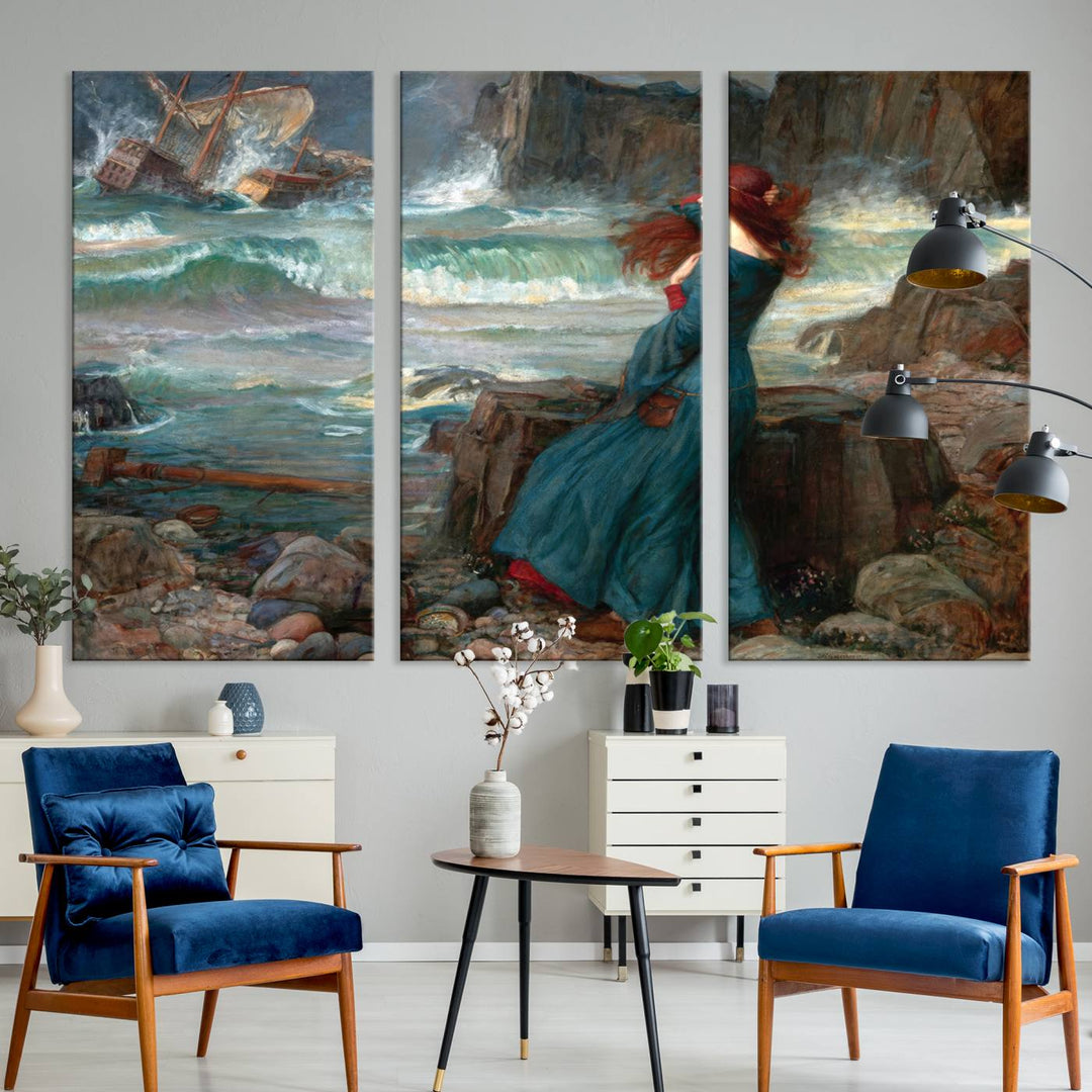 Miranda - The Tempest Canvas Print depicts a woman in a blue dress gazing at a shipwreck on a rocky shore. The artwork is ready to hang.