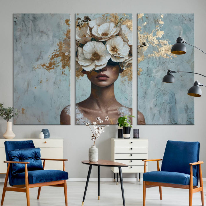 The Golden Petal Silhouette Woman Wall Art Canvas Print, a large 3-panel canvas with a textured gold floral design, serves as a luxurious centerpiece in modern glam settings. The artwork depicts a woman with flowers over her eyes against a textured background and hangs elegantly.