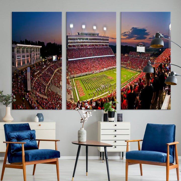 A print of a bustling Carter-Finley Stadium at dusk, featuring fans and a band, captures the essence of NC State Wolfpack football.