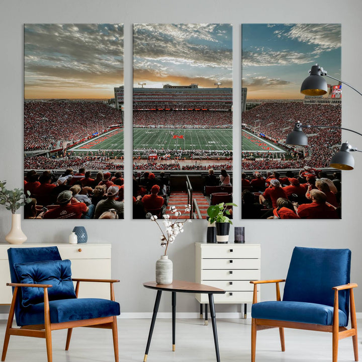 The living room features a stunning triptych of Lincoln Memorial Stadium wall art canvas print, celebrating the University of Nebraska Cornhuskers football team. This piece serves as captivating wall art, showcasing a gallery-quality finish.