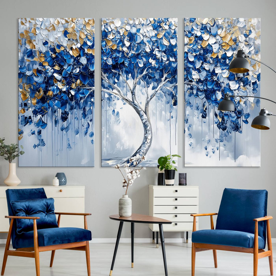 The Blue and Gold Abstract Tree Wall Art showcases a swirl trunk and features blue, silver, and gold leaves on a framed canvas print.