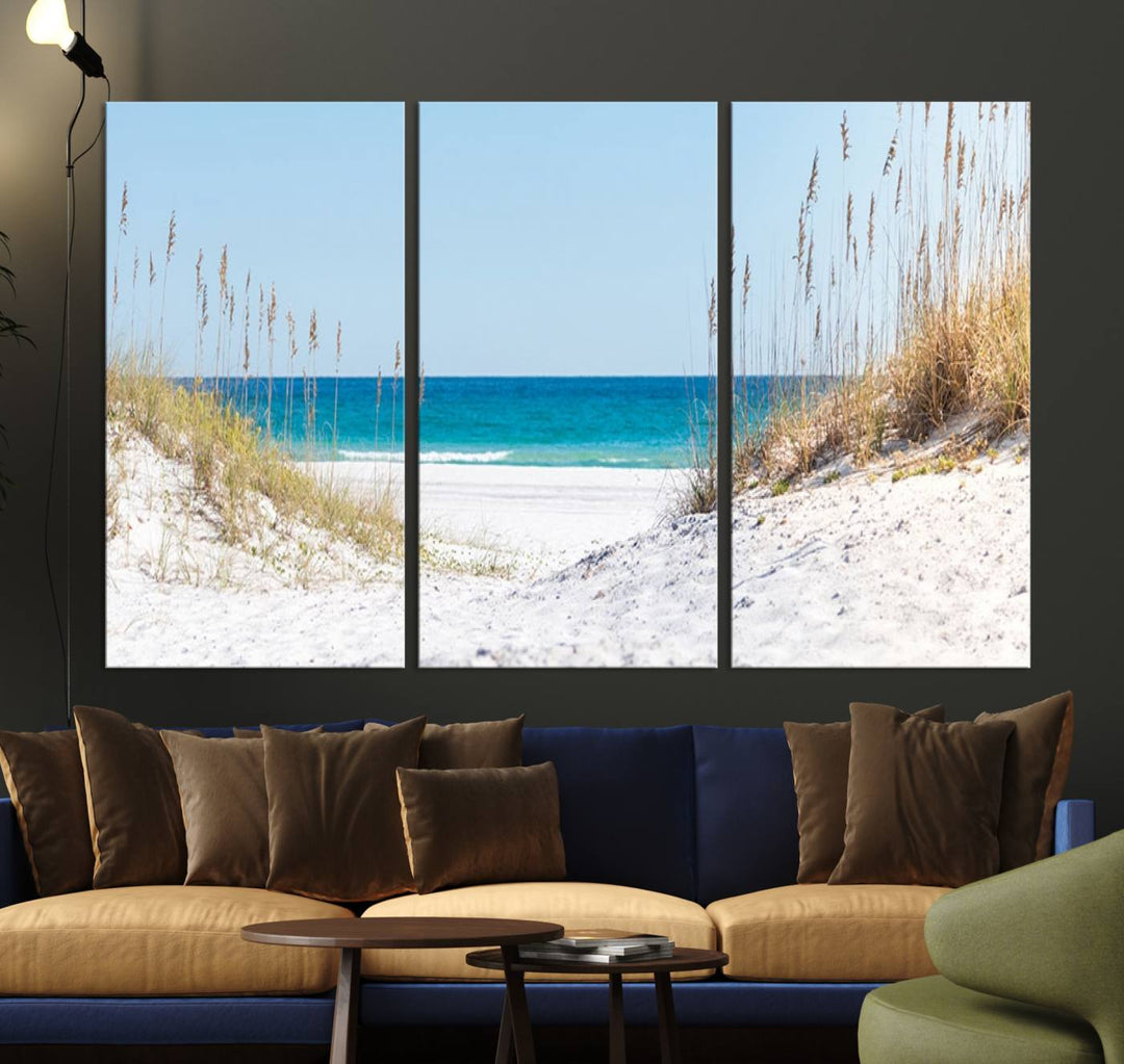 A tranquil seascape giclee print, titled "Serene Coastal Dune Path with Ocean View," features a 3-panel beach canvas wall art that captures the sandy dunes, seagrass, and ocean view to perfectly exude coastal charm.