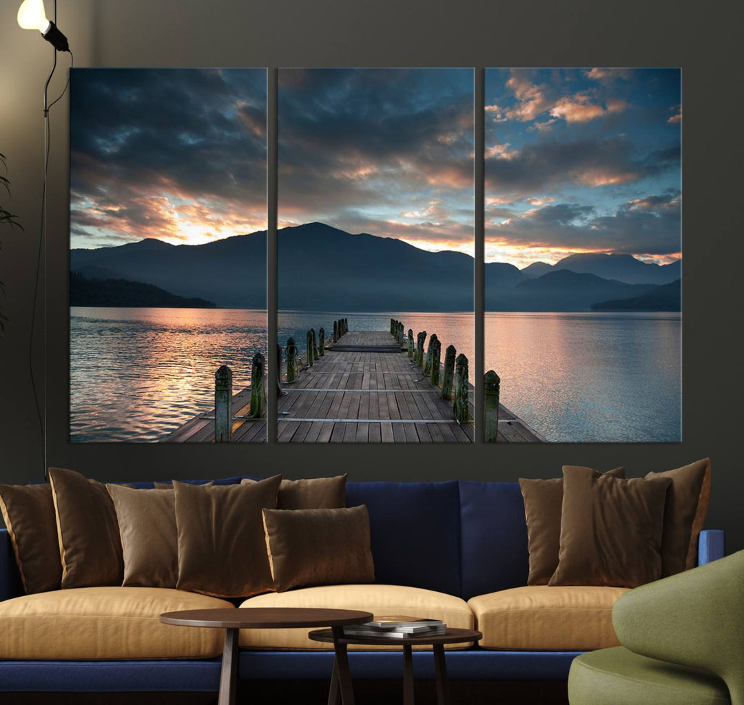 The Mountain Lake Wood Pier Canvas Wall Art depicts a serene lake and mountains, enhancing the beauty of any space.