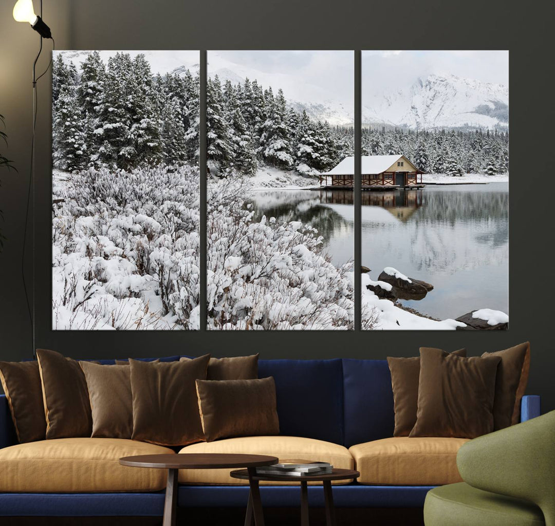 Experience the beauty of winter with the "Cabin by the Lake Canvas Wall Art," showcasing a serene snowy landscape. This rustic nature decor features a cozy cabin nestled amid snow-laden trees, set against a breathtaking mountain view, perfect for enhancing your living room.