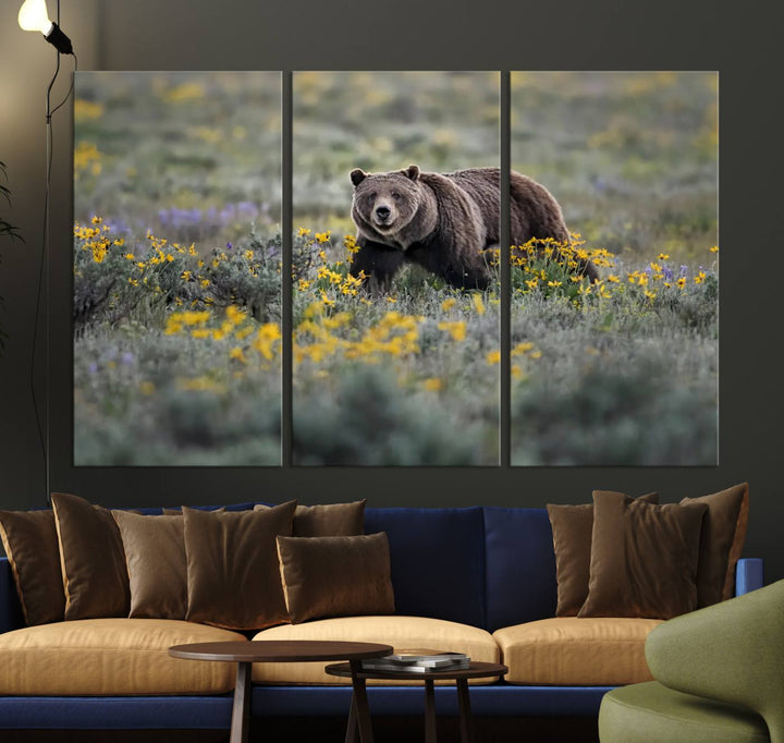 The "Grizzly 399 in Wild Flowers Wall Art Canvas Print" features a grizzly bear strolling through a field of yellow and purple flowers, beautifully showcased as a triptych. This handcrafted piece, proudly made in the USA, adds charm and sophistication to your space.