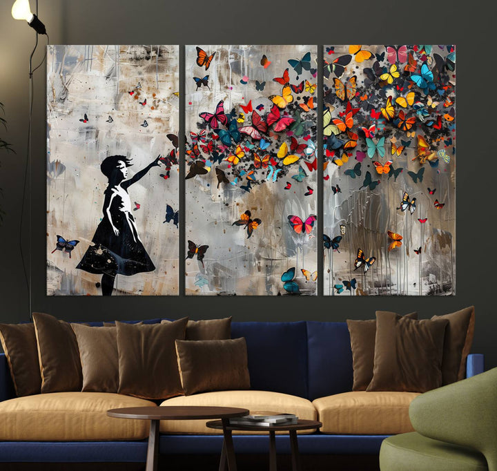 The Banksy Butterfly Girl 3-Piece Modern Graffiti Canvas Wall Art features a silhouette of a girl reaching for butterflies.