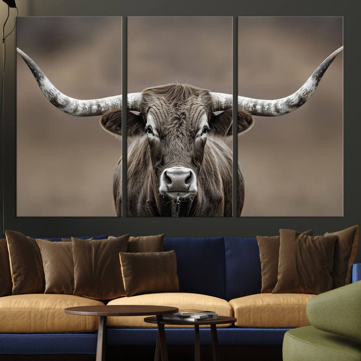 A close-up of a longhorn bull facing forward is featured in the Framed Texas Test-1, set against a blurred brown background.