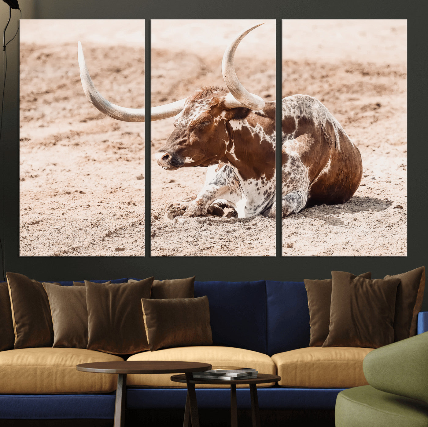 Texas Longhorn bull resting on dusty ground with warm tones, ideal for rustic western or farmhouse-themed wall decor.