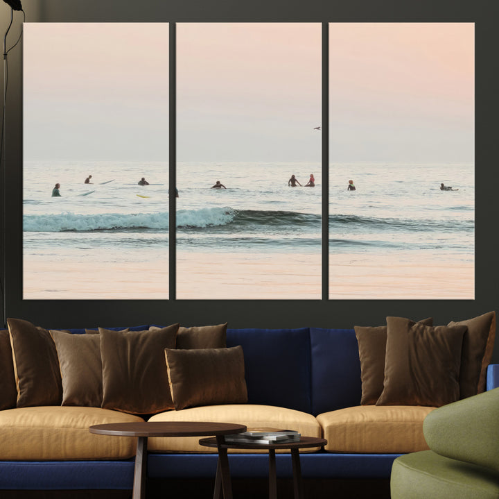 Dreamy photo of surfers waiting on soft pastel waves under a pink sunset sky, ideal for soft coastal minimalist or serene ocean-themed home decor.