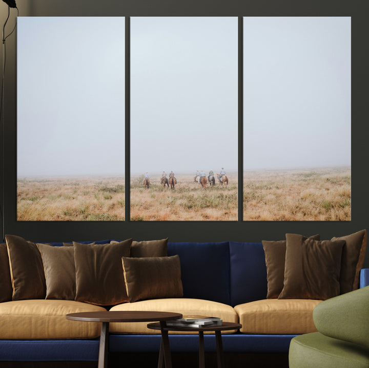 A group of horseback riders moving through a fog-shrouded field, evoking a calm Western scene with golden grasses and soft horizons.