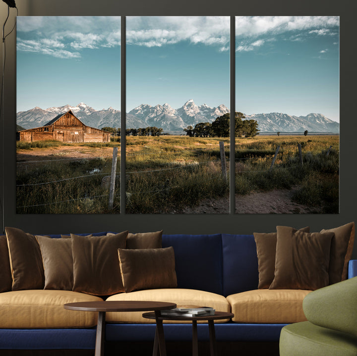 A rustic farmhouse with a wooden barn set against majestic mountain peaks under a soft blue sky, evoking peaceful countryside charm.