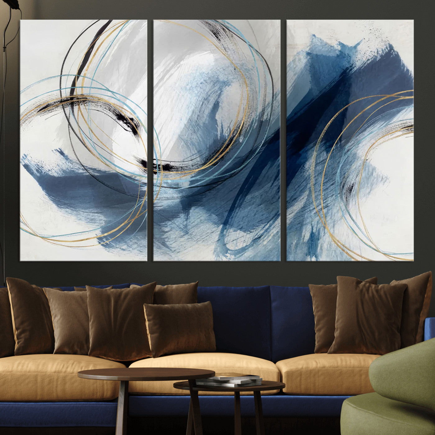 Abstract wall art featuring dynamic brush strokes in shades of blue and gray, overlaid with delicate circular line patterns in gold, black, and light blue on a white background.