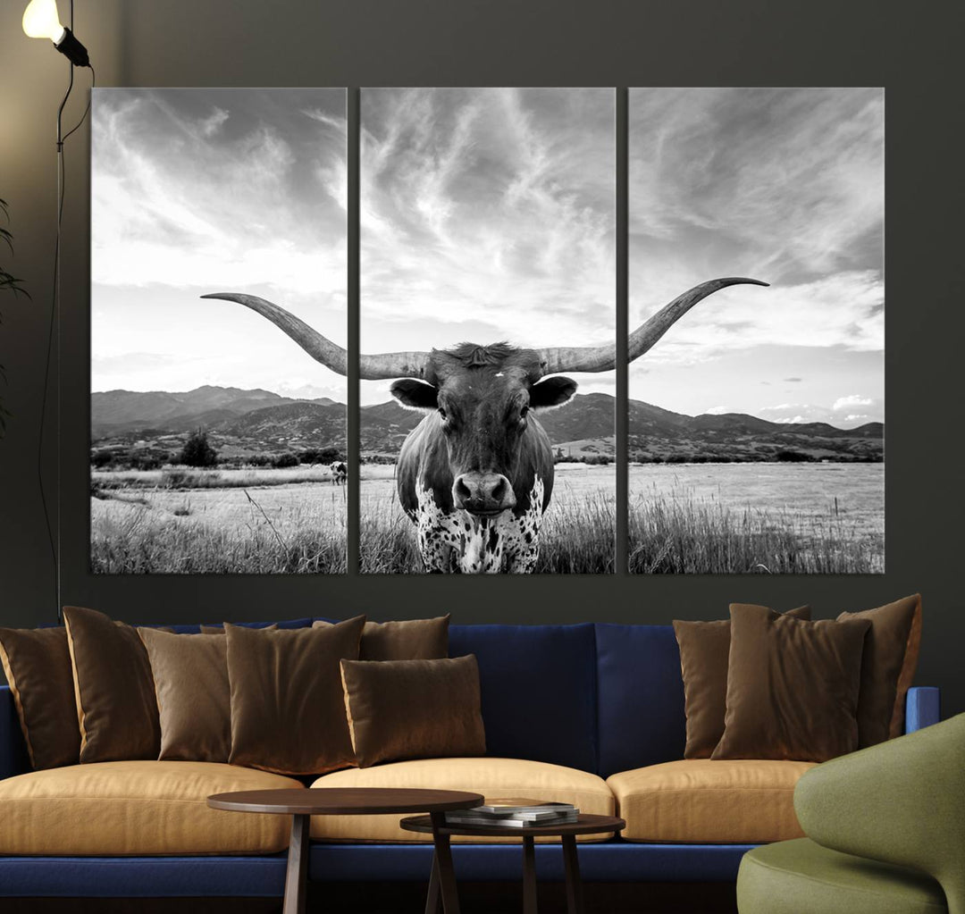 A modern living room showcases a black and white triptych of the "Longhorn Cow Wall Art Canvas Print Farmhouse Wall Art Texas longhorn wall art.