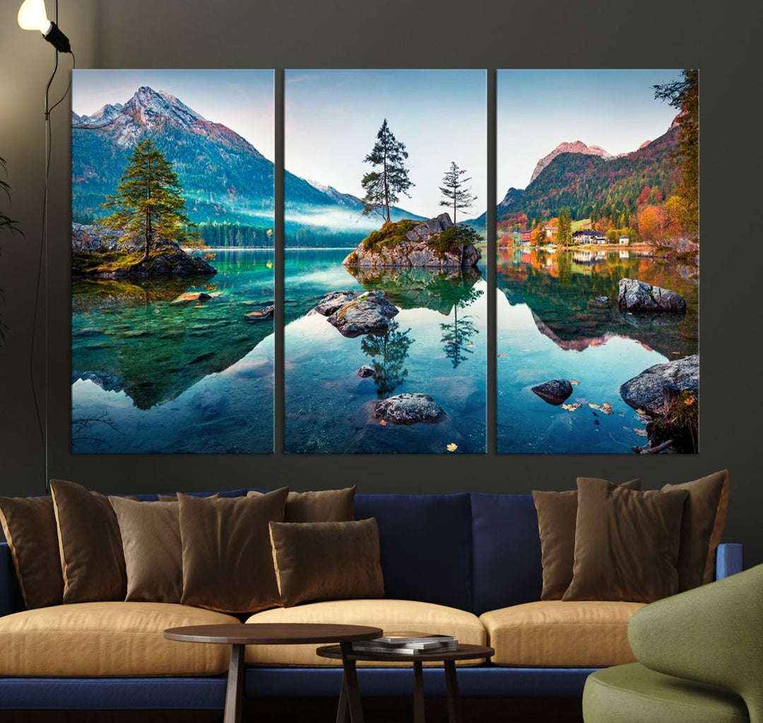 The 3-panel wall art showcases a serene mountain lake with rocky islands and trees, creating an ideal focal point for dining rooms or offices.