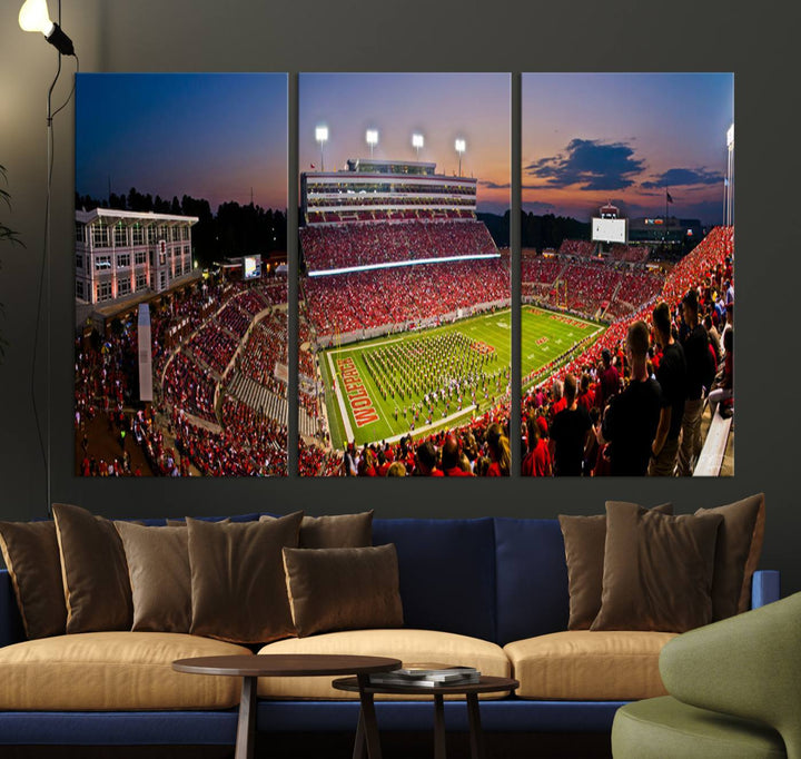 A print of a bustling Carter-Finley Stadium at dusk, featuring fans and a band, captures the essence of NC State Wolfpack football.