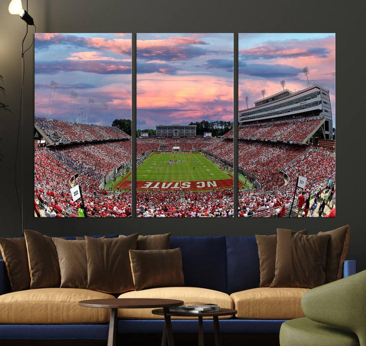 The wall art captures an NC State Wolfpack game under a vibrant sunset on triple canvas.