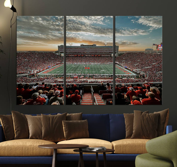 The living room features a stunning triptych of Lincoln Memorial Stadium wall art canvas print, celebrating the University of Nebraska Cornhuskers football team. This piece serves as captivating wall art, showcasing a gallery-quality finish.