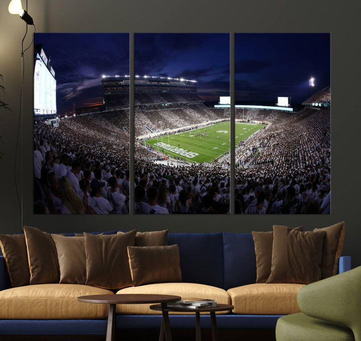 A packed football stadium at night, with bright lights and fans in white, depicted in a Michigan State Spartans Stadium wall art.