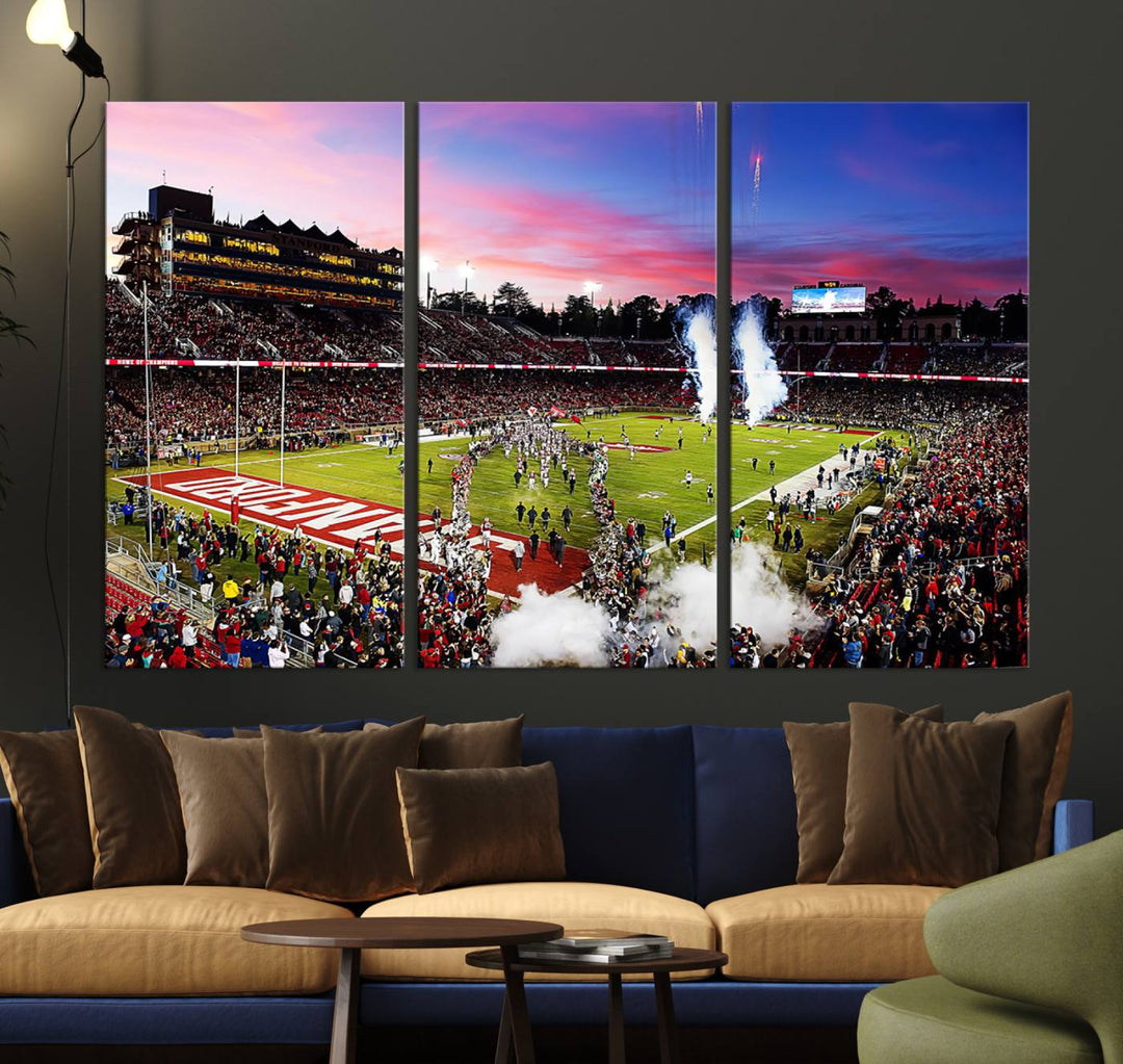 The wall art features a canvas print of the Stanford Cardinal football team, capturing players, fireworks, and smoke against the backdrop of a sunset at Stanford Stadium.