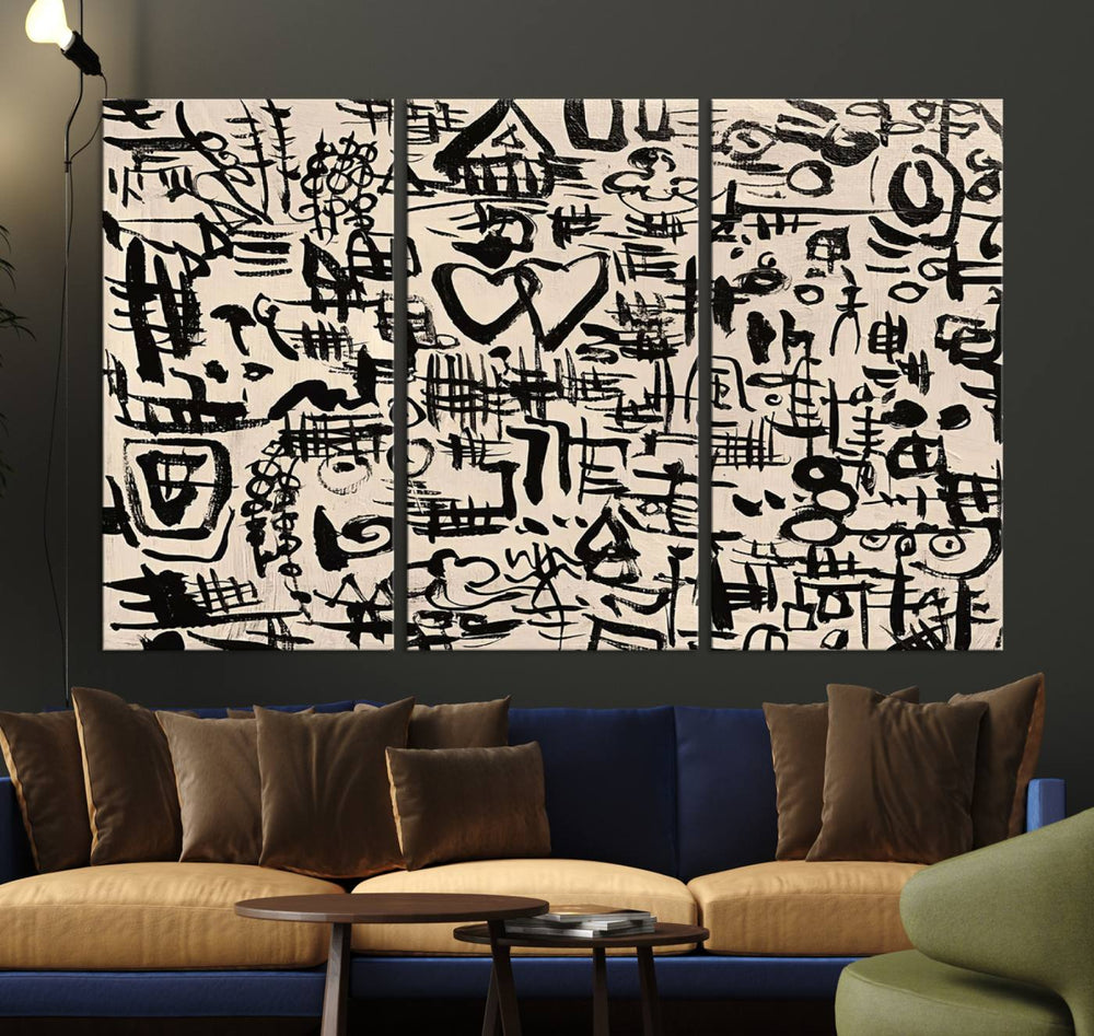 The Abstract Love and Chaos canvas is a museum-quality print featuring black symbols on a beige background, adorned with a heart and scribble design. It is framed to enhance its artistic appeal.