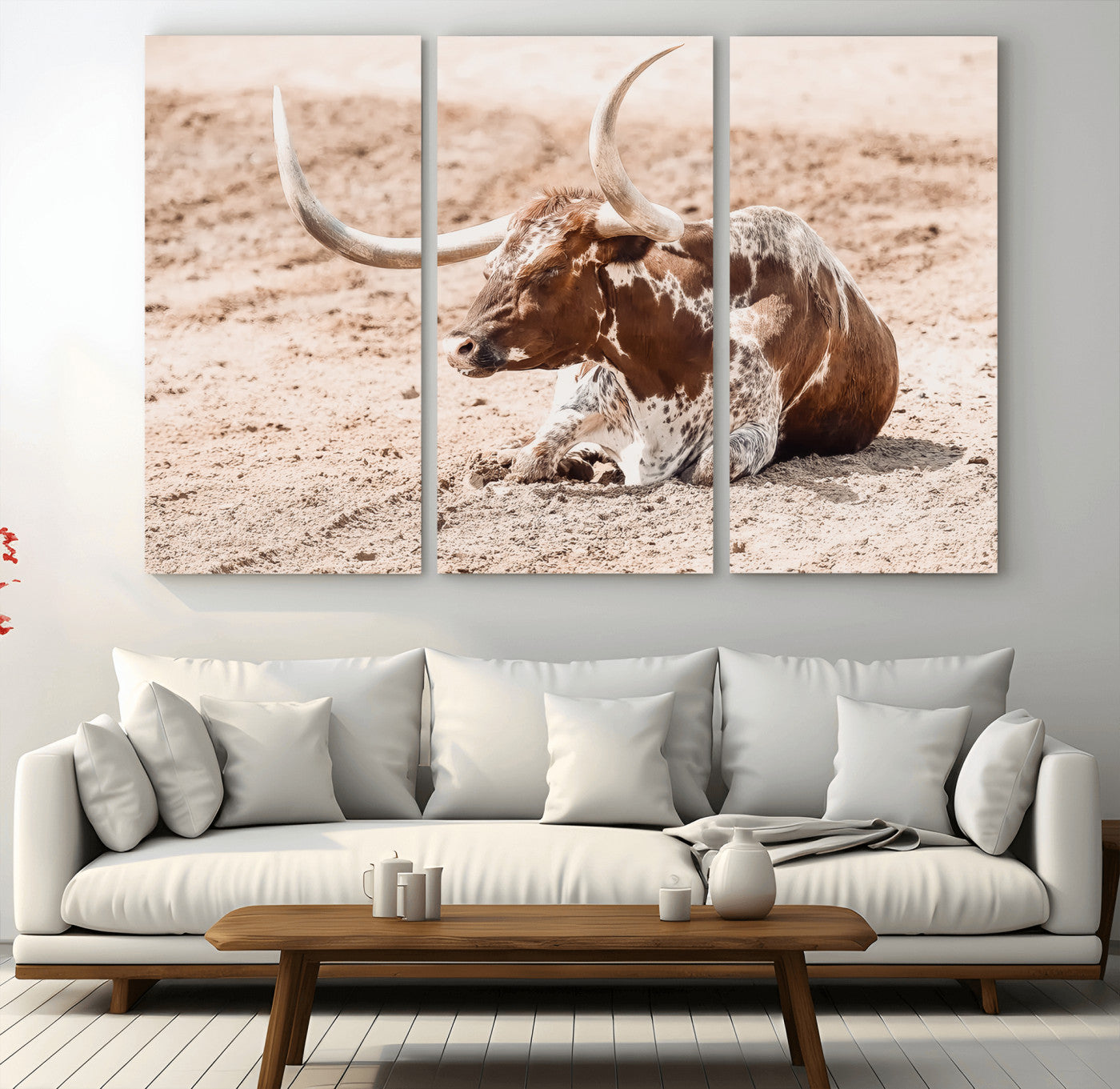 Texas Longhorn bull resting on dusty ground with warm tones, ideal for rustic western or farmhouse-themed wall decor.