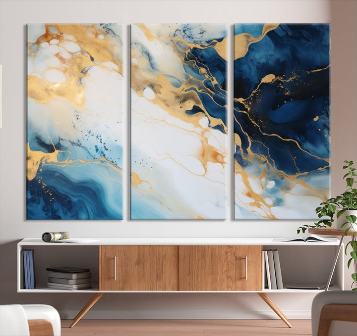 A modern living room featuring museum-quality Blue Gold Abstract Wall Art Print Contemporary art in a triptych arrangement.