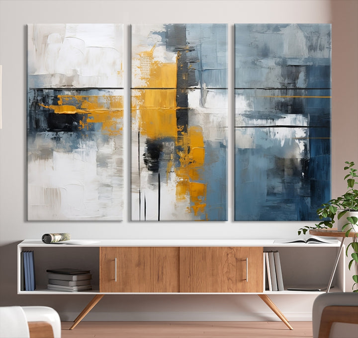 The Orange Abstract Wall Art Print features a series of white, blue, black, and yellow blocks arranged in a triptych format on museum-quality canvases. Proudly made in the USA and offered with free shipping.