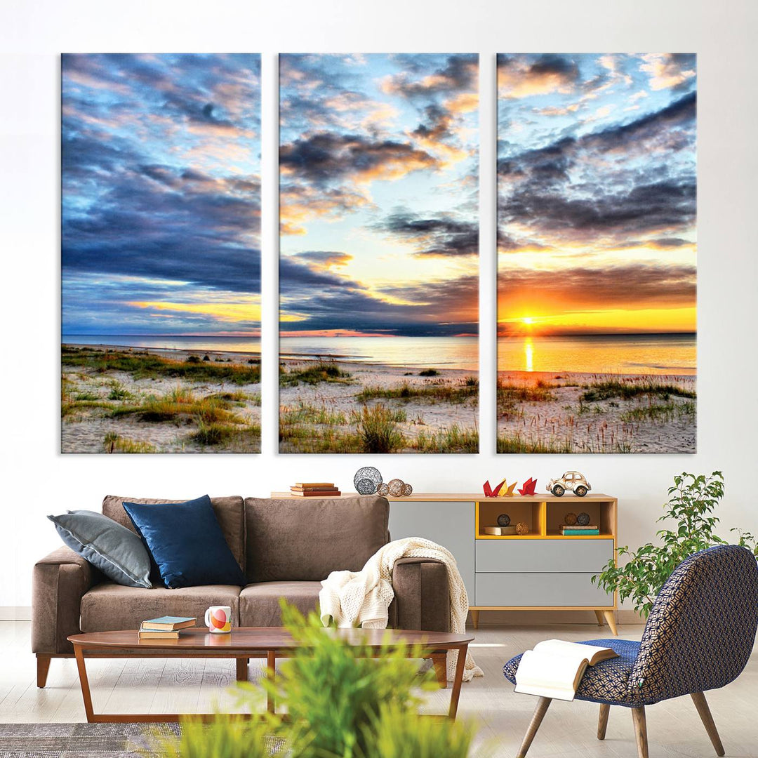 The Sunset On The Ocean canvas wall art features a beautiful beach sunset with grass and clouds.