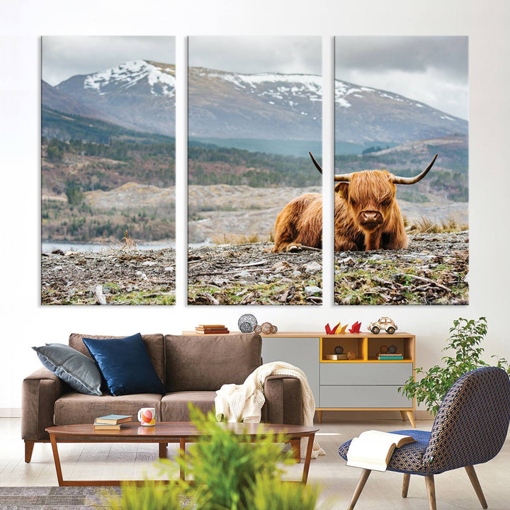 Highland Cow Horn Farm Wall Art Canvas Print is displayed against a wooden wall featuring a mountainous backdrop.