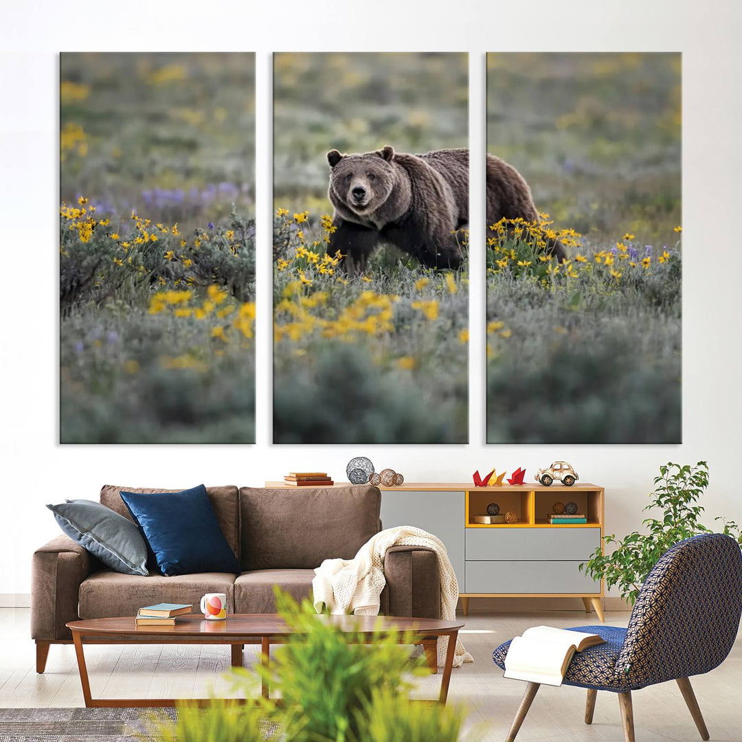 The "Grizzly 399 in Wild Flowers Wall Art Canvas Print" features a grizzly bear strolling through a field of yellow and purple flowers, beautifully showcased as a triptych. This handcrafted piece, proudly made in the USA, adds charm and sophistication to your space.