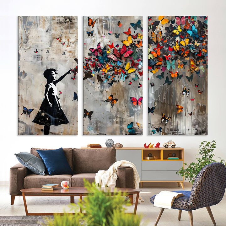 The Banksy Butterfly Girl 3-Piece Modern Graffiti Canvas Wall Art features a silhouette of a girl reaching for butterflies.