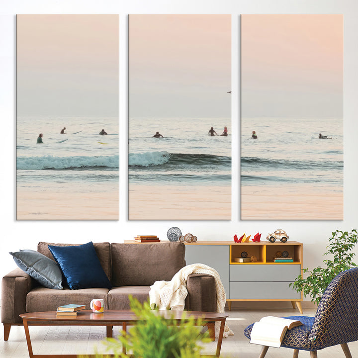 Dreamy photo of surfers waiting on soft pastel waves under a pink sunset sky, ideal for soft coastal minimalist or serene ocean-themed home decor.