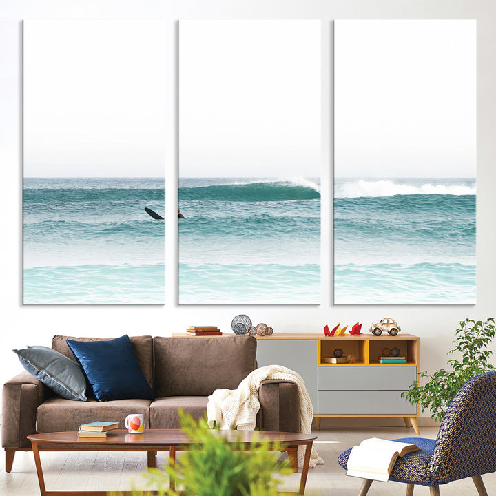 Minimalist photo of a lone surfer on calm aqua waves under bright sky, perfect for Scandinavian coastal or serene ocean-inspired home decor.