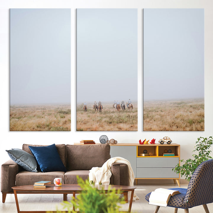 A group of horseback riders moving through a fog-shrouded field, evoking a calm Western scene with golden grasses and soft horizons.